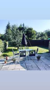 - une table, des chaises et un parasol sur la terrasse dans l'établissement Odea Hot tub Holiday Cottage, à Dumfries