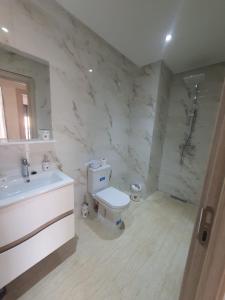 bagno con servizi igienici bianchi e lavandino di Victoria Mohammed V-Apartment a Bouskoura