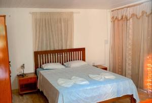 um quarto com uma cama com duas toalhas brancas em Pousada Villa Mariposa em Beberibe