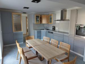 a kitchen with a wooden table and chairs at Pokoje u Krysi in Rzymkowice