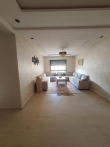 un ampio soggiorno con due divani e un tavolo di Victoria Mohammed V-Apartment a Bouskoura