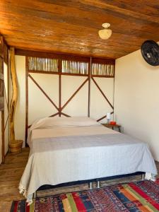 um quarto com uma cama grande e um tecto em madeira em Puerta al Mar Ecolodge Glamping em Tubará