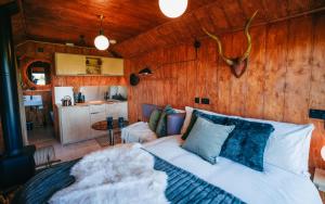 a bedroom with a white bed and wooden walls at ARA Cabin - Mêl in Pwllheli