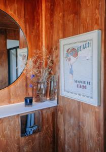 a mirror and a shelf with vases and a picture at ARA Cabin - Mêl in Pwllheli +32 photos