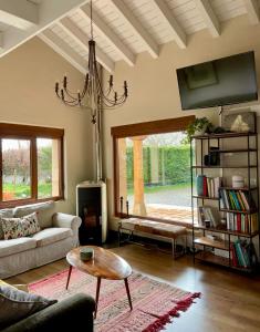 sala de estar con sofá, mesa y lámpara de araña en Casa rural en Fontibre, en Espinilla