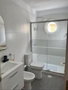 a white bathroom with a toilet and a shower at Apartment Playa Las Americas in Playa de las Americas