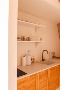 een keuken met houten kasten en een spoelbak bij SIRKA SPACE Hotel in Tsetula