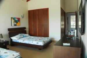 a bedroom with a bed and a desk at Casa Arcoíris: Espectacular casa en Cartagena con Acceso directo a la Playa in Cartagena de Indias +19 photos
