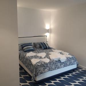 a bedroom with a bed with blue and white sheets at La casina del Conte in Naples