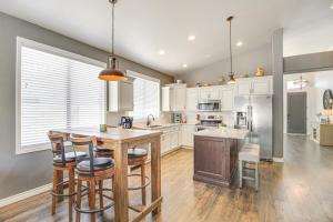 a kitchen with white cabinets and a wooden island with bar stools at Stunning Oro Valley Home Near Catalina State Park in Oro Valley