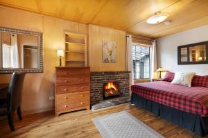 a bedroom with a bed and a fireplace at Elkhorn Lodge in Banff