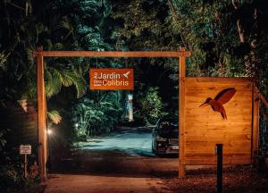 Au Jardin Des Colibris Ecolodge&Spa في ديساي: بوابة خشبية مكتوب عليها مستعمرات نحل لايهانه