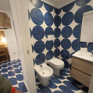 a blue and white bathroom with a toilet and a sink at La casina del Conte in Naples
