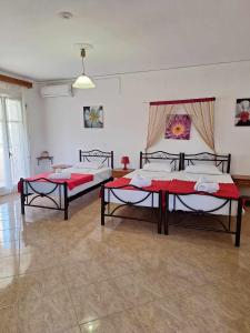 two beds in a room with red sheets at Casa Alema Verde in Ýpsos