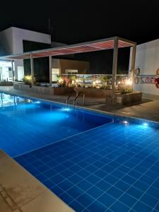 uma piscina à noite num hotel em Apartamento cerca a la Playa em Gaira