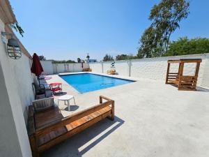 a swimming pool with a bench next to a house at MARYAND in Soto la Marina
