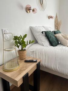 - une chambre avec un lit et une table avec télécommande dans l'établissement Au coeur de Montmedy, à Montmédy