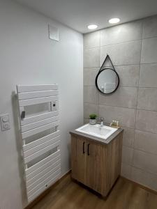 une salle de bain avec un lavabo et un miroir dans l'établissement Au coeur de Montmedy, à Montmédy