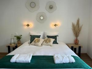 une chambre avec un grand lit blanc avec deux oreillers dans l'établissement Au coeur de Montmedy, à Montmédy