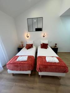 deux lits dans une chambre avec une télévision au mur dans l'établissement Au coeur de Montmedy, à Montmédy 10 autres photos