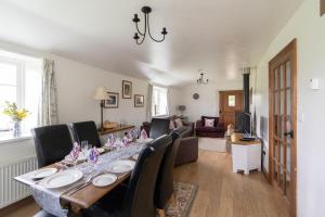 ein Esszimmer mit einem langen Tisch und Stühlen in der Unterkunft Coachmans Cottage in Loxton in Loxton
