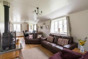 Coachmans Cottage in Loxton في Loxton: غرفة معيشة مع أريكة ومدفأة
