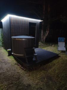 um deque de madeira com uma banheira de hidromassagem com luzes em Morska Szyszka & Leśne SPA em Odargowo