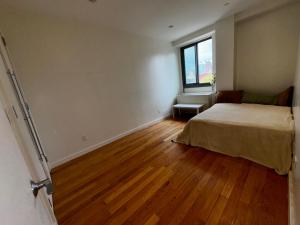 an empty room with a bed and a window at Delancey Tower in Jersey City