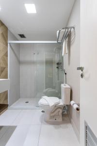 uma casa de banho branca com um WC e um chuveiro em Maximus Luxury in Wyn Berrini - WTC II em São Paulo