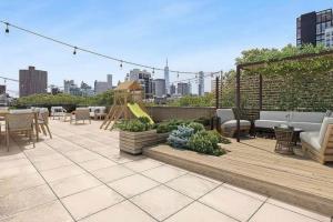 a patio with tables and chairs and a playground at Delancey Tower in Jersey City