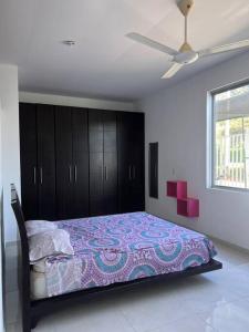 een slaapkamer met een bed en een plafondventilator bij Casa campo en Melgar in Nilo