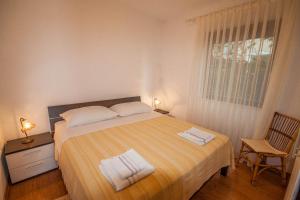 - une chambre avec un lit et 2 serviettes dans l'établissement Apartments Rosanda, à Pakoštane