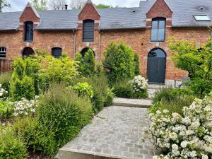 een bakstenen huis met een tuin ervoor bij Aux Bois Dorés de la Ferme de sorval, animaux de la ferme, fitness in Selvigny