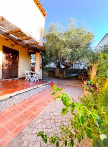聖瑪麗亞納瓦雷的住宿－Casa L ulivo，一座带桌子和树的房屋的庭院