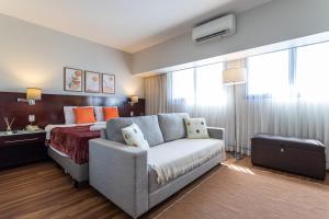 um quarto de hotel com um sofá e uma cama em Maximus Luxury in Wyn Berrini - WTC II em São Paulo