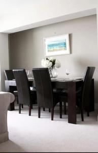 a dining room with a black table and chairs at MacKenzie Lodge in Lahinch
