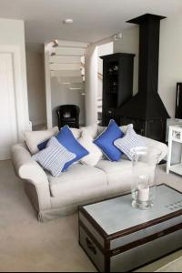 a living room with a white couch with blue pillows at MacKenzie Lodge in Lahinch
