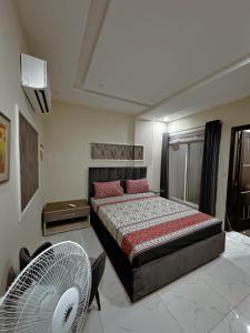 - une chambre avec un lit et un ventilateur dans l'établissement Sheher e Shauq - Manzar (Eiffel tower view), à Rāmkot