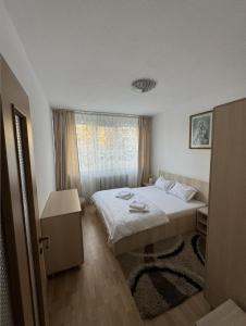 a small bedroom with a bed and a window at Muntean Residence in Sibiu +7 photos