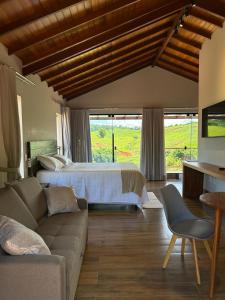 a living room with a bed and a couch at Hotel Fazenda Palmeiras in Rio Casca +36 photos