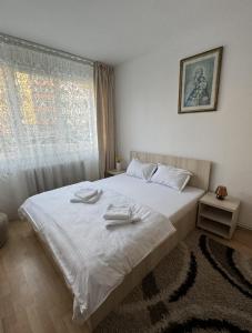 a bedroom with a white bed with towels on it at Muntean Residence in Sibiu