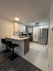 a large kitchen with white cabinets and a counter top at Luxurya in Drummondville