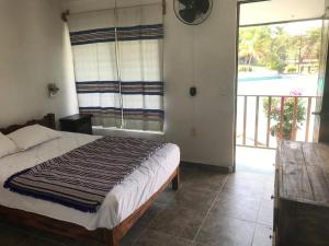 1 dormitorio con cama y ventana grande en Las Ventanas en Xochitepec