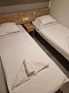 two beds with white sheets and a napkin on them at Adriastay 360 in Jezera