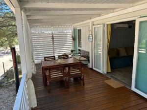 a porch with a table and chairs on a deck at Adriastay 360 in Jezera