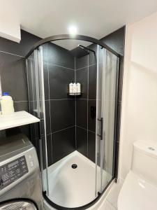 a shower with a glass door in a bathroom at Luxurya in Drummondville +17 photos