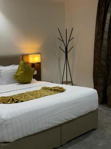 a bedroom with a bed with a yellow blanket on it at Desert Paradise Hotel فندق جنة الصحراء in Al Bad‘