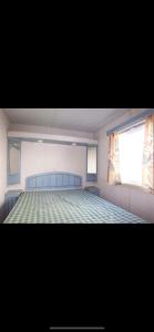 a bedroom with a large bed and a window at Mobilhome Vieux Boucau les bains in Vieux-Boucau-les-Bains