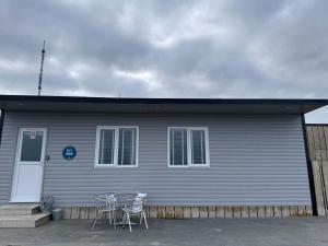 a gray house with chairs and a table in front of it at Sheriffs Mountain Lodge in Derry Londonderry