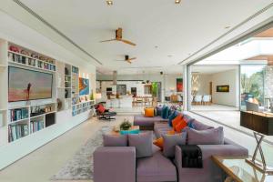 sala de estar con sofás morados y TV en Villa White Skies, en Ban Na Phong
